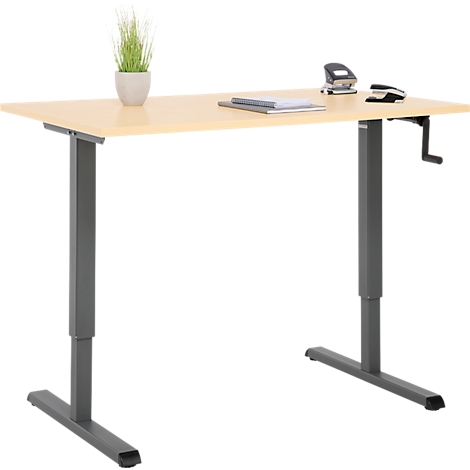 Bureau réglable en hauteur de couleur claire avec plantes, agrafeuses et manivelle.