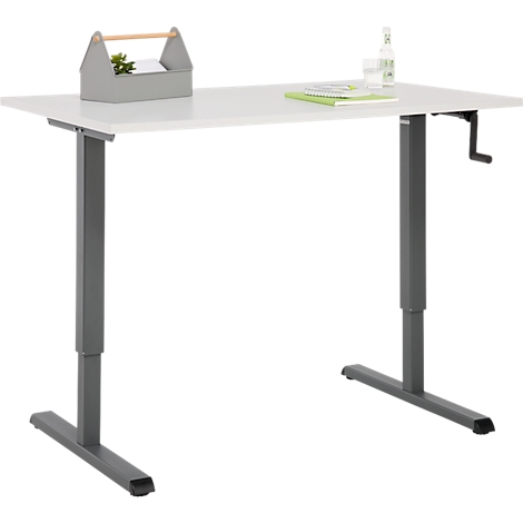 Bureau réglable en hauteur avec plateau blanc et pieds gris. Sur le plateau se trouvent une boîte à outils grise, une bouteille et un livre.