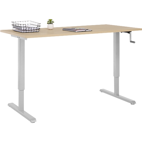 Bureau beige à hauteur réglable. Il y a un panier, une plante et un carnet.