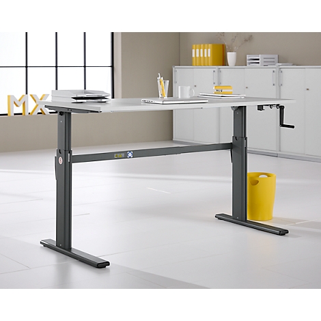 Bureau réglable en hauteur dans un bureau lumineux. Cadre gris, plateau blanc, poubelle jaune.