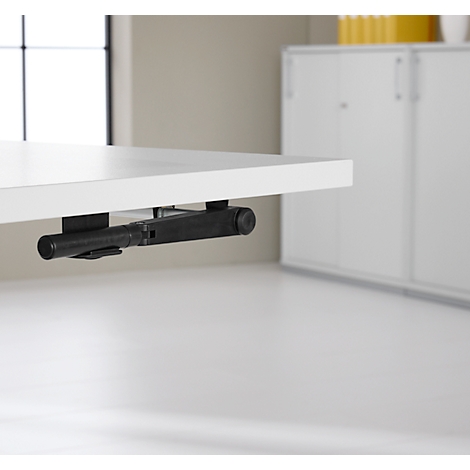 Porte-stylo noir monté sous le plateau de la table. Le porte-stylo est fixé au dessous d'un plateau de table blanc.