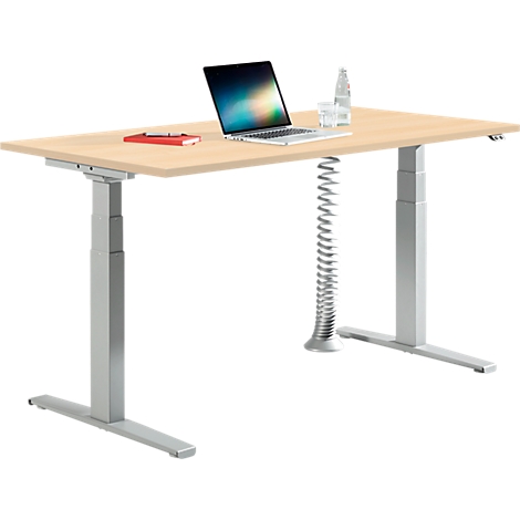 Un bureau réglable en hauteur avec un plateau en bois et un cadre argenté, avec un ordinateur portable et un carnet rouge.