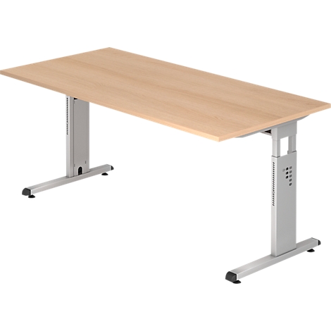 Un bureau réglable en hauteur avec un plateau brun clair et des pieds argentés. Les pieds sont en forme de T à la base.
