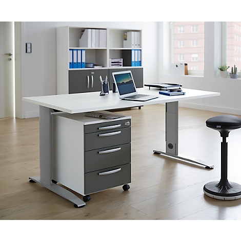 Een modern bureau met laptop, stoel en rolcontainer op een kantoor. Kasten op de achtergrond.