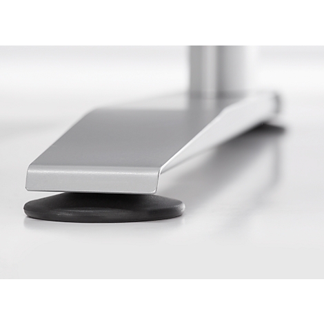 Close-up van een zilveren metalen voet op een zwarte rubberen buffer, staand op een wit oppervlak.