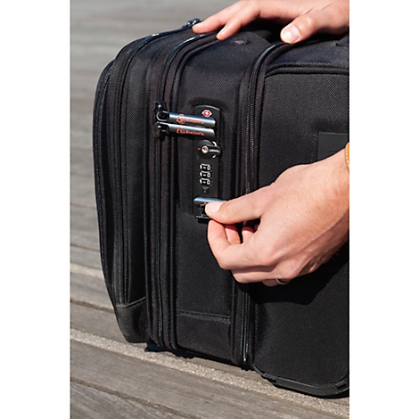 Close-up of a man opening a black luggage with a combination lock.