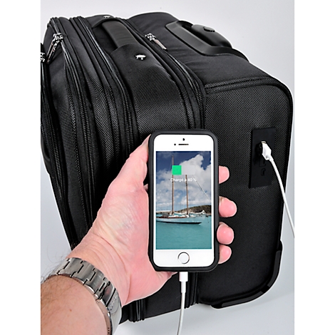 Black suitcase with a charging cable attached to a mobile phone. A sailboat is on the display. The suitcase is charging.