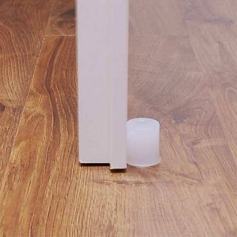 Gros plan : Porte blanche, dessous patin de meuble blanc sur plancher en bois.