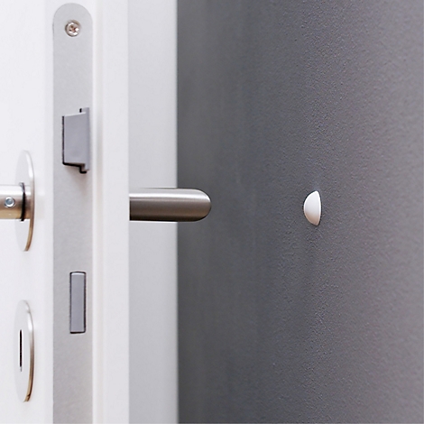 Gros plan d'une porte blanche avec poignée en acier inoxydable et un objet blanc, semi-circulaire sur le mur.