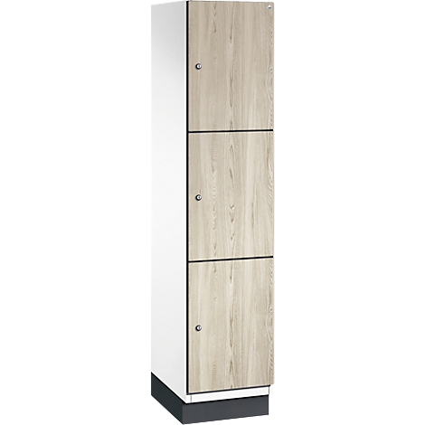 Hoge kast met drie deuren in houtlook, wit frame en zilveren knoppen.