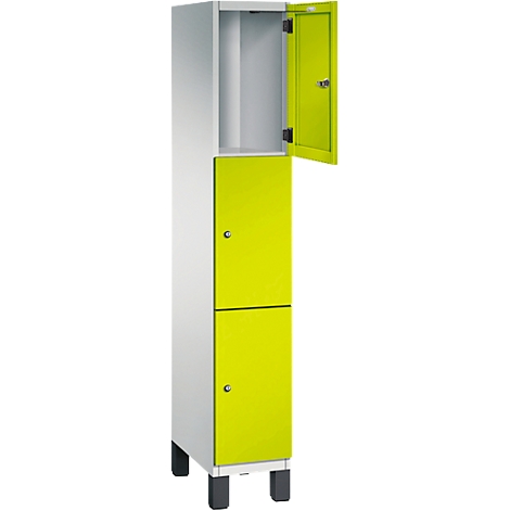 Kast met gele deuren, één open, de andere gesloten. Witte behuizing, staand op zwarte voetjes.