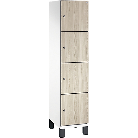 Hoge kast met vier lades en witte zijkant; licht houten fineer met zilveren knoppen.