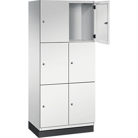 Witte locker met zes compartimenten, waarvan één open. Grijze basis, alle deuren met zilveren knoppen.