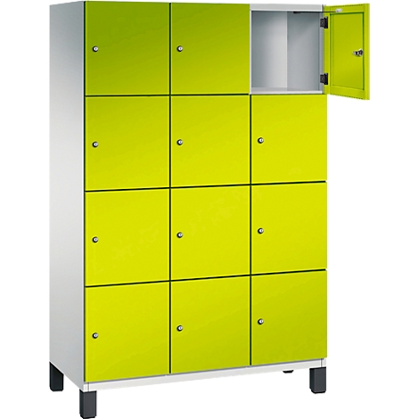 Kast met twaalf neongele deuren, waarvan één open. Zwarte poten, wit frame. Een eenvoudig, functioneel ontwerp.