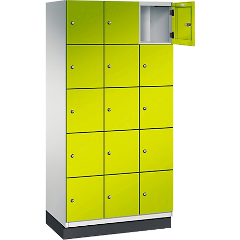 Kastenwand met 12 neon groene deuren, één deur open.