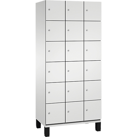 Witte kast met 15 deuren, zwarte poten en metalen knoppen.
