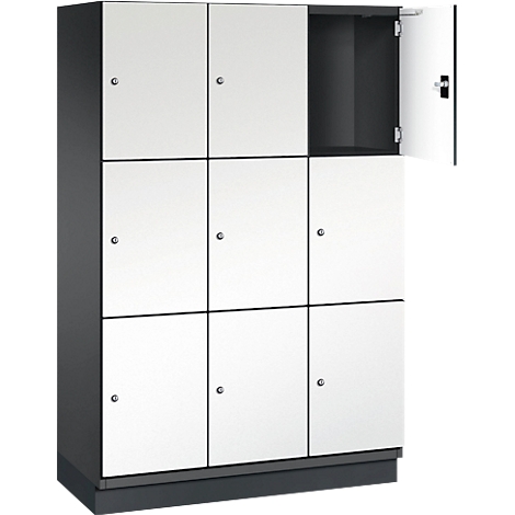 Grijze locker met negen vierkante deuren, waarvan één open is.