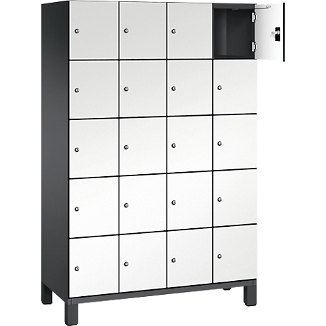 Een witte locker met 16 compartimenten, één compartiment open. Zwarte randen, zilveren knoppen.