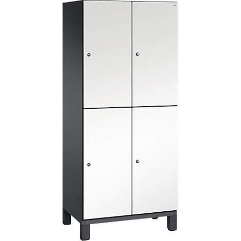 Schrank mit vier Türen, weiss mit dunklen Rahmen und Beschlägen, steht auf kurzen Füßen.