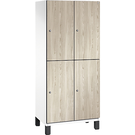 Ein weißer Schrank mit vier Türen, die eine Holzmaserung imitieren. Schwarze Rahmen und Füße. Kleine, silberne Griffe.