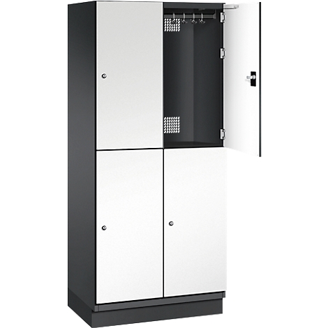 Ein Spind mit zwei Türen geöffnet, mit Kleiderstange und Lochblech-Belüftung.