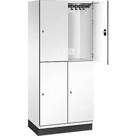 Weißer Schrank mit vier Türen. Obere rechte Tür offen. Im Inneren Haken und ein Lochmuster.