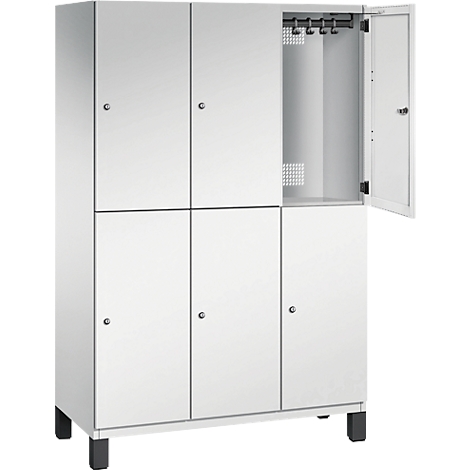 Weißer Spind mit geöffneter Tür. Im Inneren Haken und Lüftungsschlitze.