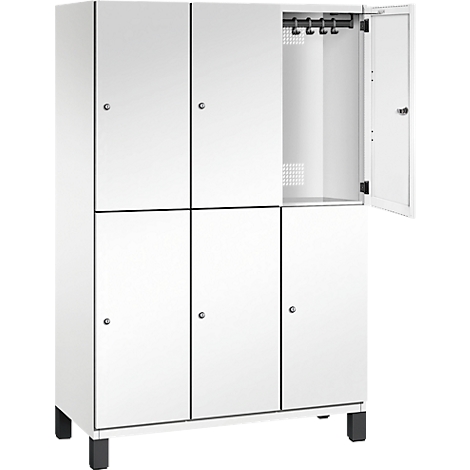 Weißer Spind mit sechs Türen, eine Tür ist geöffnet. Schwarze Füße und Metallhaken im Inneren.