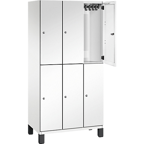 Weißer Schrank mit sechs Türen, eine davon geöffnet. Haken und Belüftungslöcher sichtbar. Schwarze Füße.