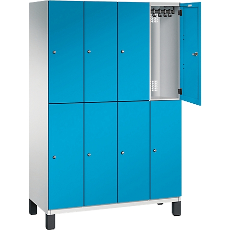 Ein Spind in Blau-Weiß. Eine Tür ist geöffnet, dahinter Haken und eine Lüftungsöffnung.