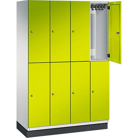 Schrank in Hellgrün mit offenem Fach. Silberne Griffe und Haken. Ein grauer Sockel steht auf weißem Hintergrund.