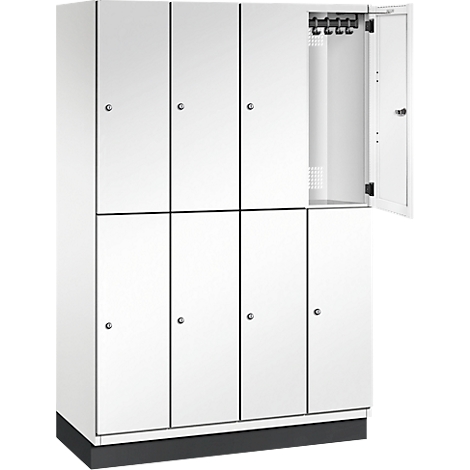 Weißer Spind mit acht Fächern, ein Fach ist geöffnet, Haken an der Innenseite.