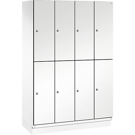 Weißer Spind mit acht Türen. Die Türen sind mit Metallknöpfen versehen und durch schwarze Linien voneinander abgegrenzt.