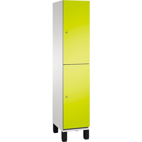 Kast met gele deuren en witte zijkanten. Staat op zwarte voeten, minimalistisch design.