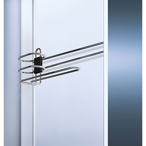 Ein Chrom-Hosenbügel mit drei Stangen an einer weißen Tür.