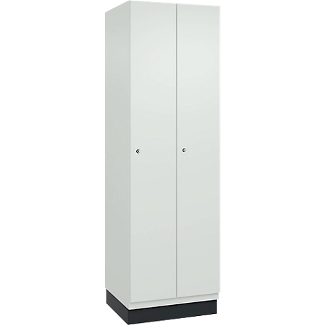Een witte kast met twee deuren en kleine knoppen. De kast staat op een zwarte sokkel.