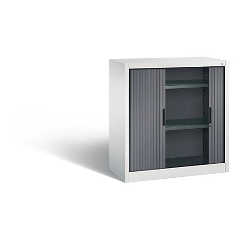 White filing cabinet with gray roller shutters, two interior shelves and black handles. Shadow on the left.
