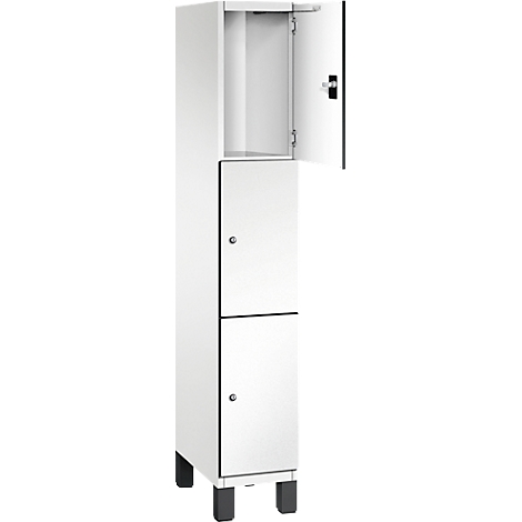 Weißer, schmaler Schrank mit drei Türen; eine Tür ist geöffnet.