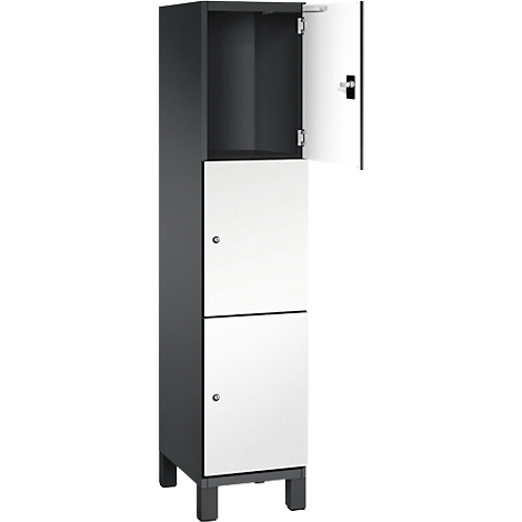 Schrank in Grau mit weißen Türen, eine Tür geöffnet.