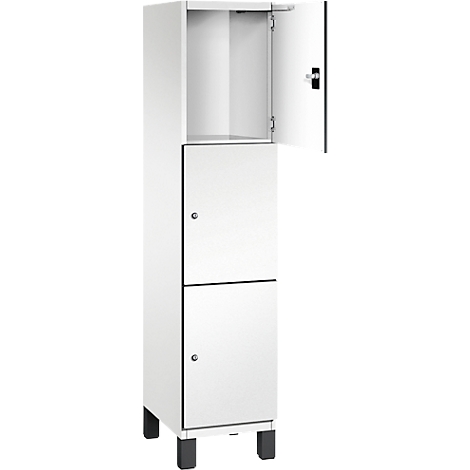 Weißer Schrank mit zwei Türen, eine offen. Schwarze Füße und Beschläge.