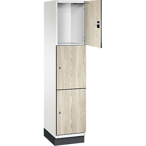 Ein weißer Spind, mit Holzmaserungstüren und einer offenen Tür.