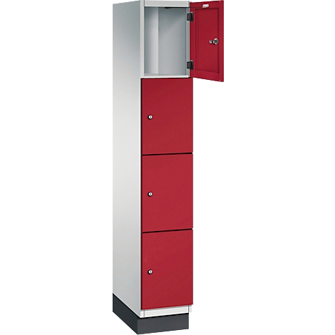 Ein weiss-roter Spind mit offener Tür. Drei rote Türen unterhalb, oben eine offene weisse Tür.