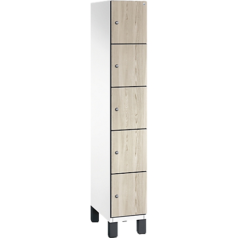 Schrank mit Holzfronten und silberfarbenen Knöpfen. Fünf Türen, weißer Korpus, steht auf schwarzen Füßen.