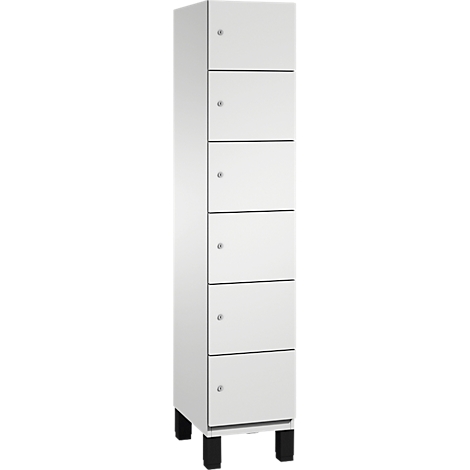 Ein hoher, weißer Schrank mit sechs Schubladen und schwarzen Füßen.