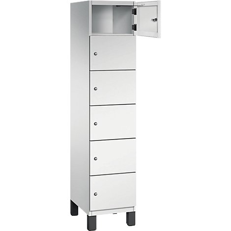 Ein weißer Schrank mit sechs Fächern, die mit kleinen Knöpfen verschlossen sind. Eine Tür ist geöffnet.