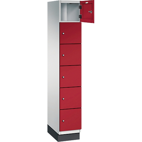 Ein Spind mit roter Tür, die obere Tür ist offen. Darunter sind 5 rote Fächer, die mit kleinen Knöpfen geöffnet werden.