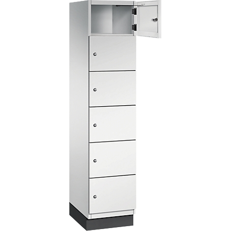 Weißer Schrank mit sechs Fächern, oben eines geöffnet. Grauer Sockel und Türknöpfe.