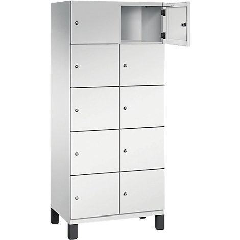 Weißer Spind mit acht Fächern, einem geöffneten Fach und schwarzen Füßen.