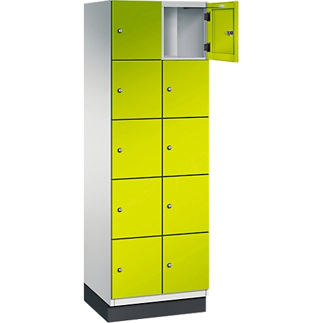 Ein hoher Spind in Weiß und Limettengrün. Eine Tür ist geöffnet.