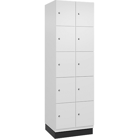 Ein weißer Spind mit zehn Türen, jede mit einem silbernen Knauf, steht auf einem schwarzen Sockel.